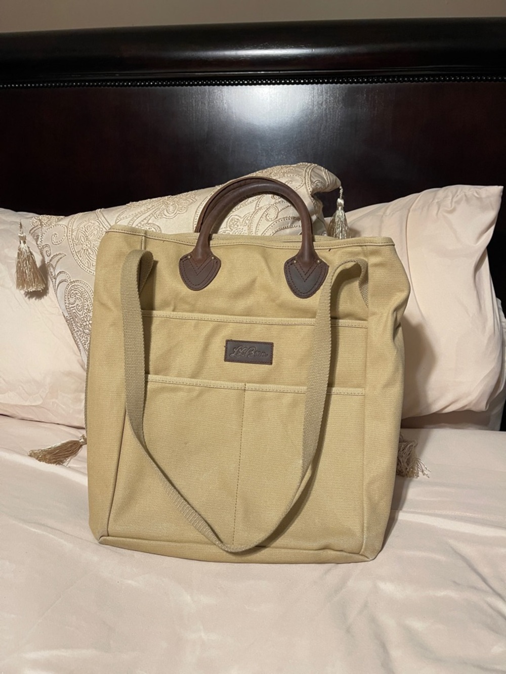 LL Bean Stonington beige canvas tote with brown leather handles.